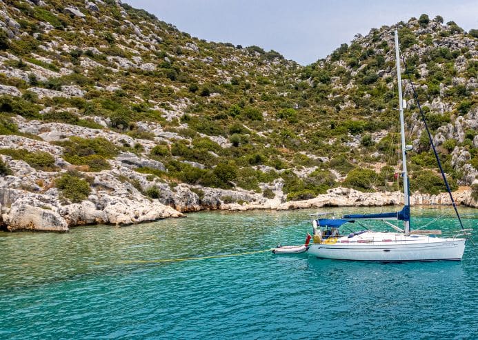 Photo d'un bateau dans une crique pour la location de voilier en Corse avec skipper de My Way Yachting.