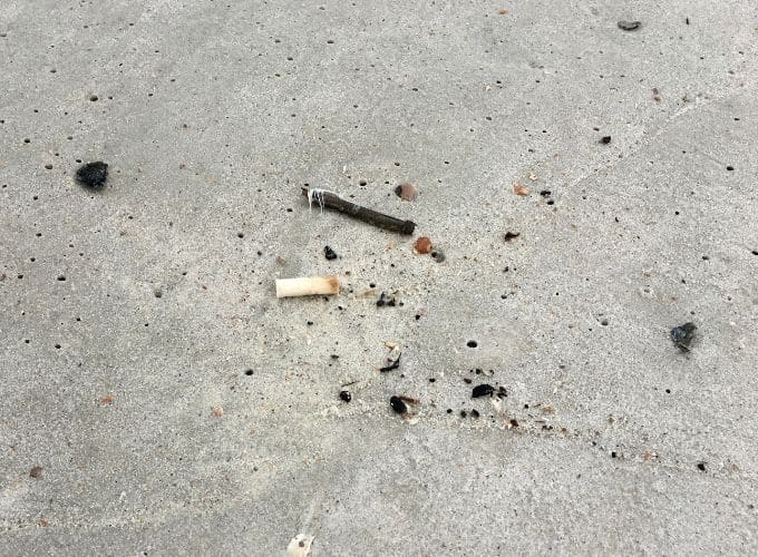 pollution sur la plage photo mégot cigarette sur le sable en Corse.